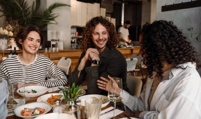 a group of women sitting at a table with food and drinks